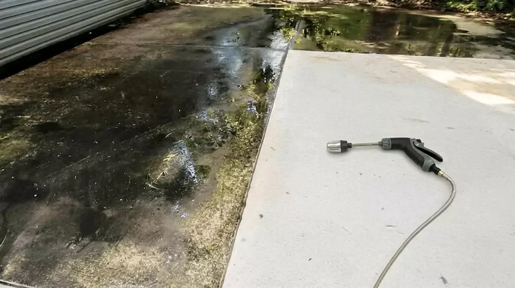 Jetterix test on a narrow concrete strip with years of algae buildup — clear cleaned line through the dirty area